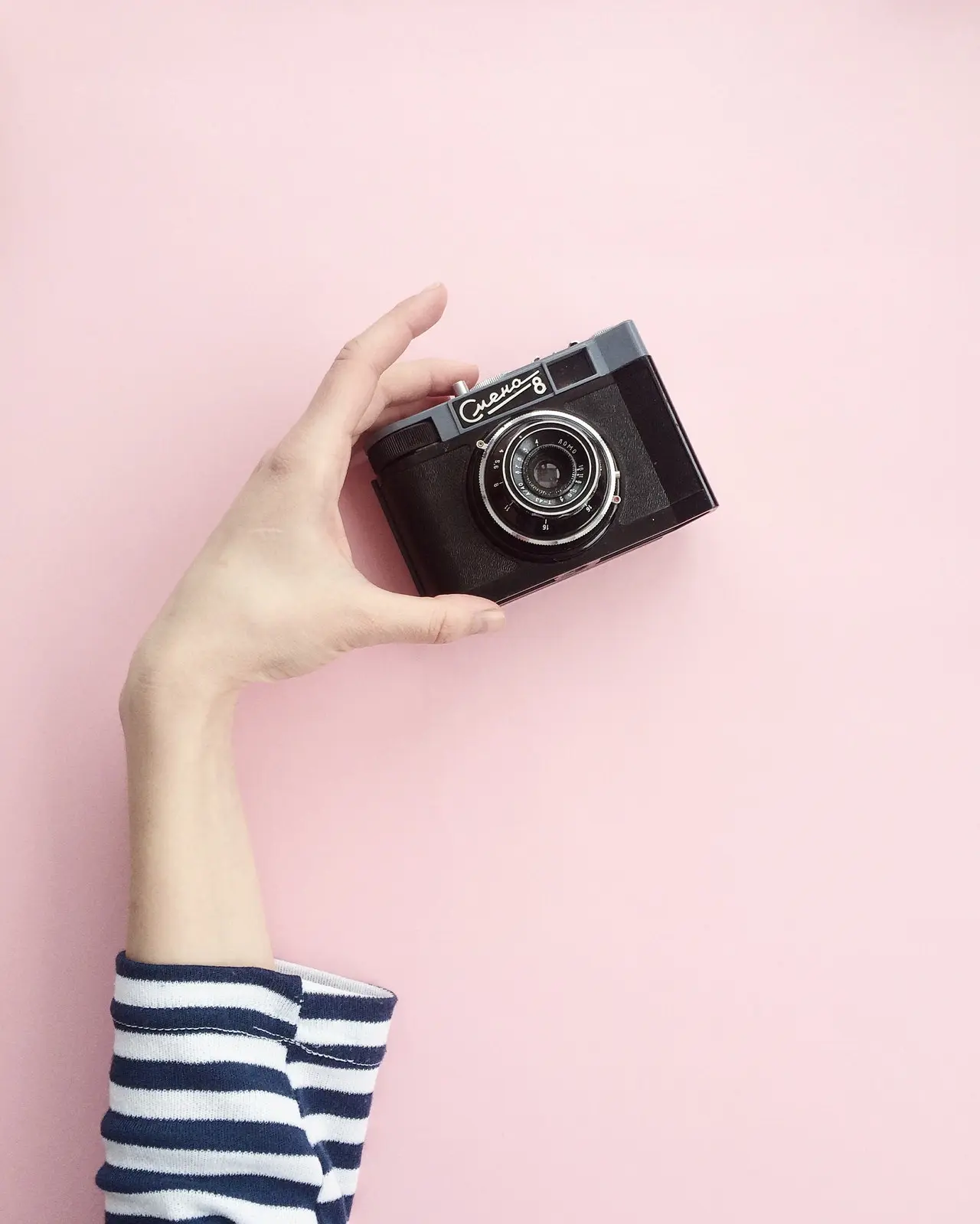 un bras brandissant un appareil photo