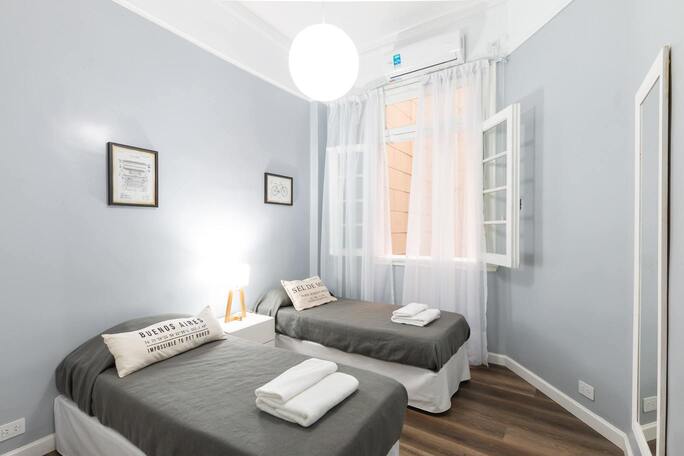 chambre épurée grise et blanche avec lits simple